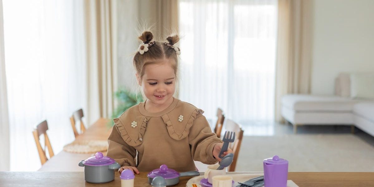 Smiling young girl plays with colorful toy tableware at home, enjoying a playful afternoon.